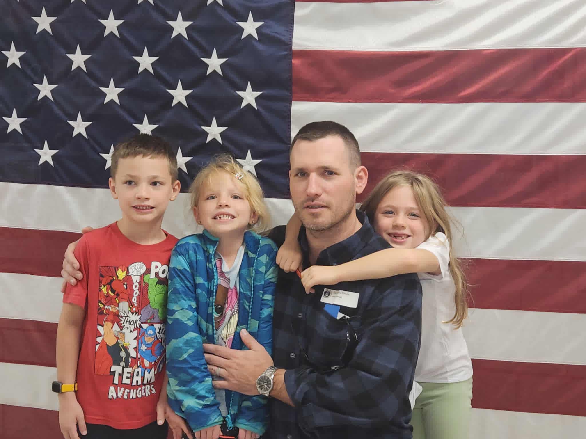 The founder of Just The Tip Cigars with his kids in front of the American flag